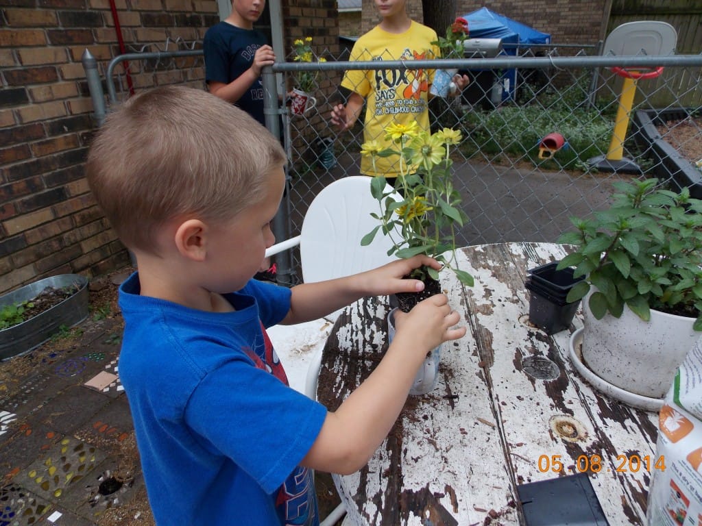 school age child planting a flower for mom