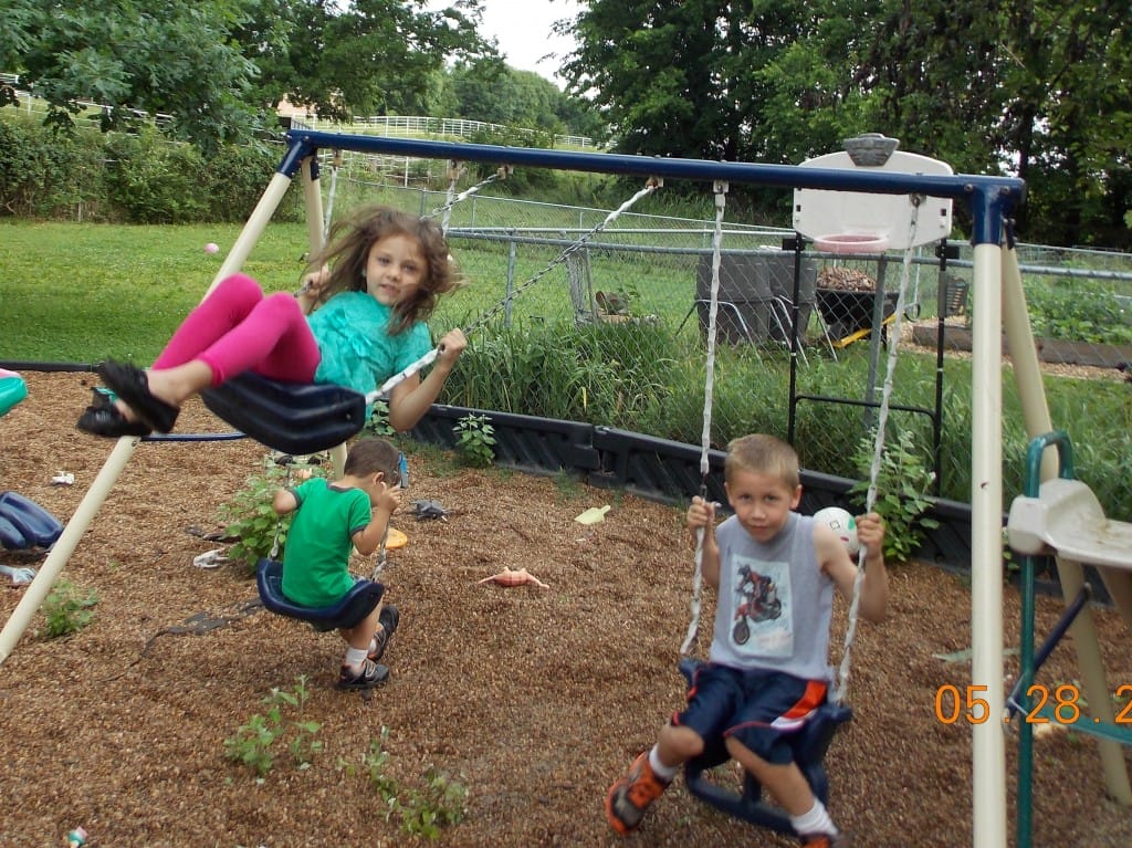 Kids swinging on a swingset in outdoor play time