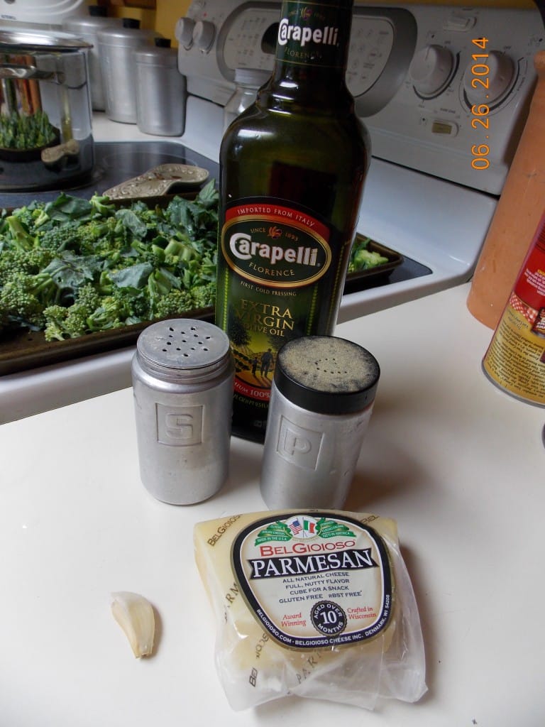 Roasted broccoli ingredients, cut up broccoli florets, olive oil, salt, pepper, parmesan cheese and a garlic clove.