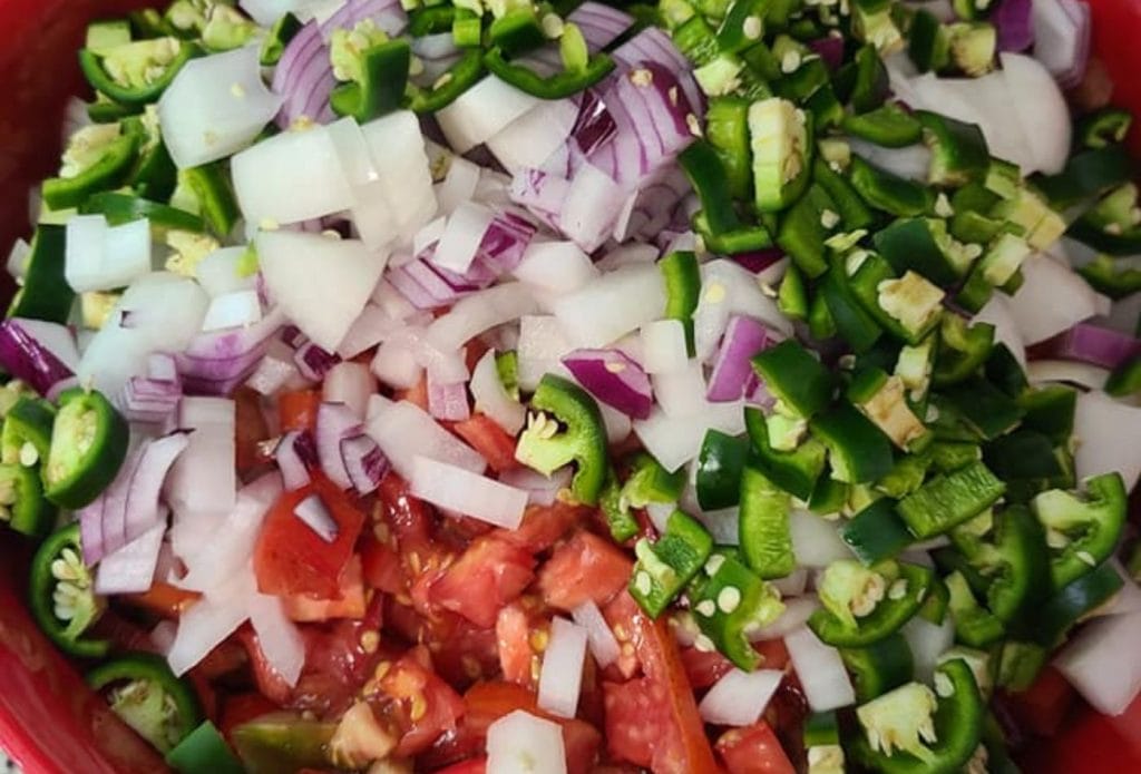 Diced tomatoes, onions, and jalapenos in a bowl