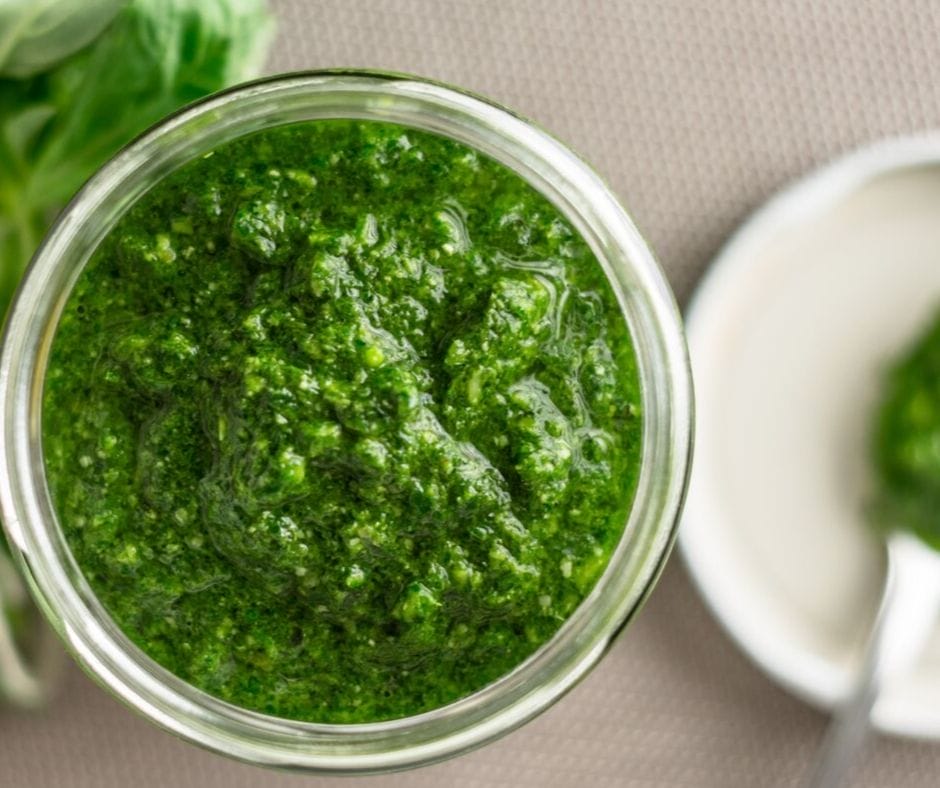 Basil pesto in a mason jar on the counter