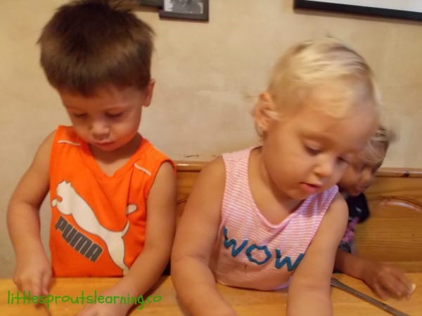 kids cutting apples with butter knives at the table
