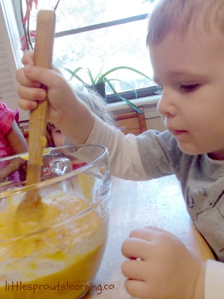 child stirring a bowl of batter to cook