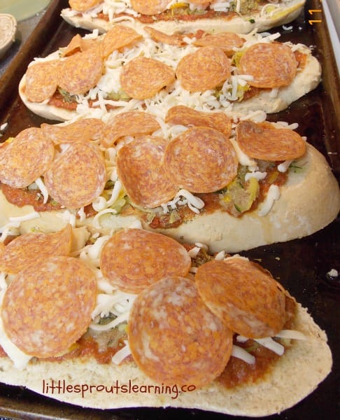 french bread pizzas with hidden vegetables getting ready to go in the oven