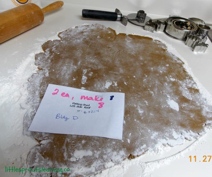 gingerbread dough rolled out on the counter with patterns ready to be cut.