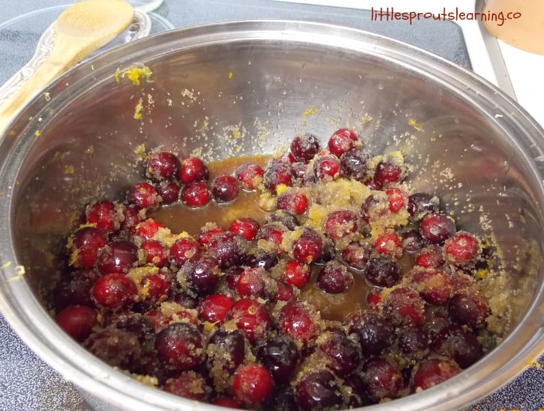 pan of cranberry sauce with orange zest and sugar on the stove