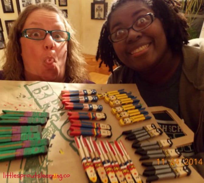 Silly faces holding up clothespin superhero ornaments we just made.