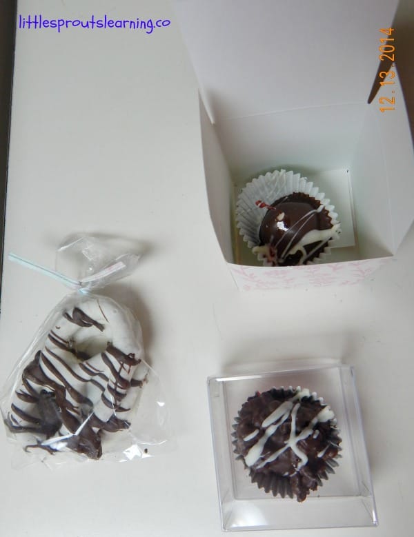 gift wrap homemade chocolates, one chocolate in a box, one in a clear container and one in a cello bag.