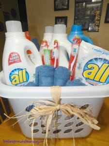 gift packaging laundry gift, laundry basket filled with laundry supplies and tied with raffia bow.