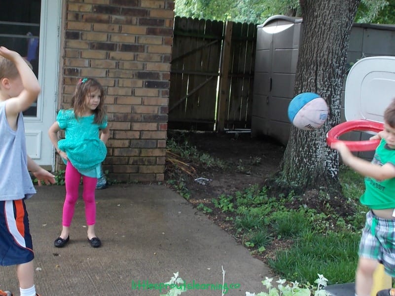 Kids playing basketball on preschool playground in outdoor play