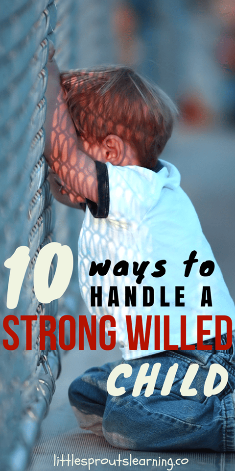a small child upset leaning against a fence