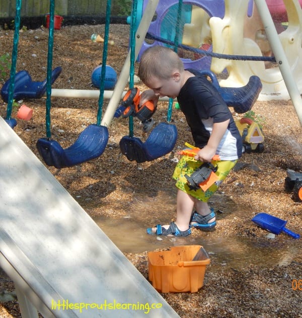 water party day, boy splashing in water puddle from sprinkler