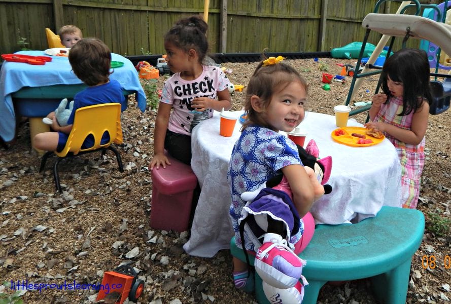 kids having a summer picnic on the playground at preschool