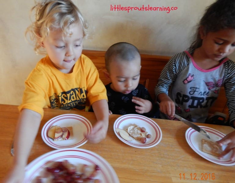 fruit pizza making at the table, kids putting fruit on top of pizza