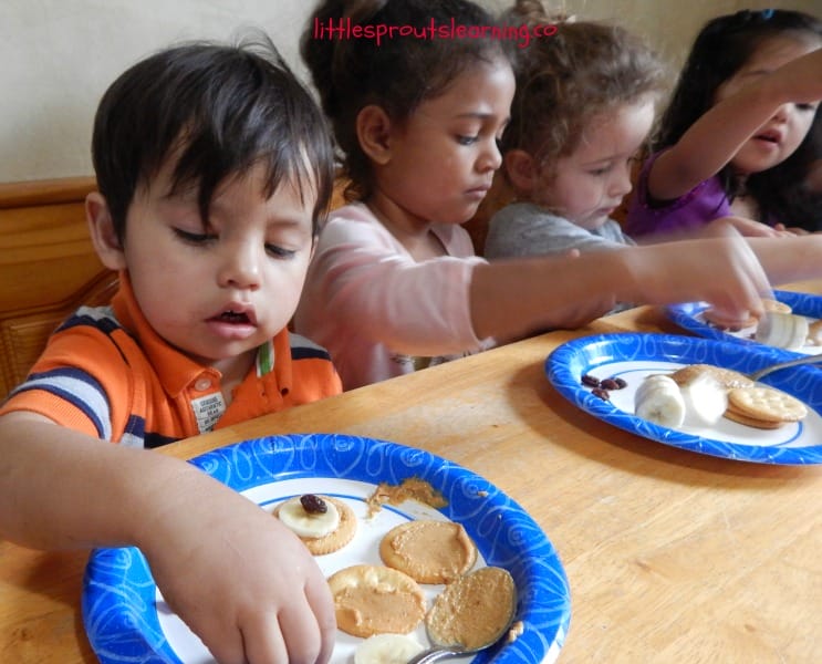 kid's making cat eye snacks at the table