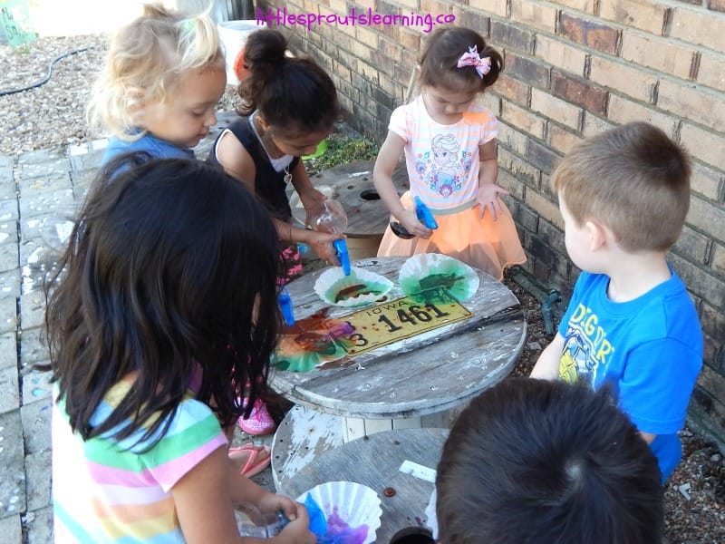 kids using spray watercolors on coffee filters to paint at daycare