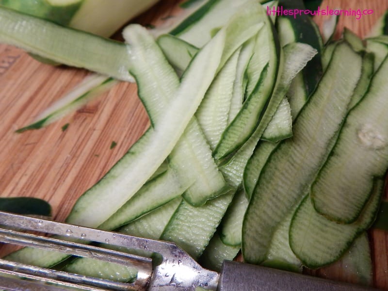 cutting board full of cucumber peels