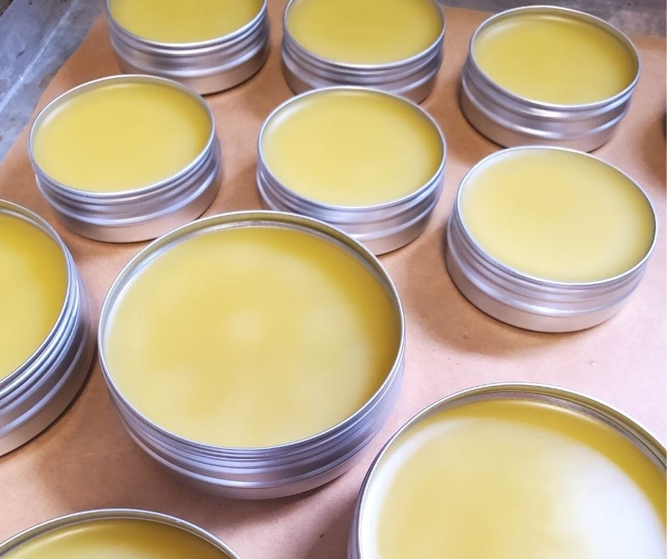 open tins of homemade healing salve on the counter