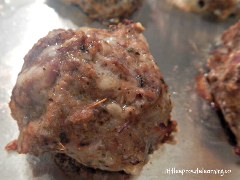 frozen meatball recipe for bulk cooking, close up of a hot meatball fresh from the oven on a sheet tray