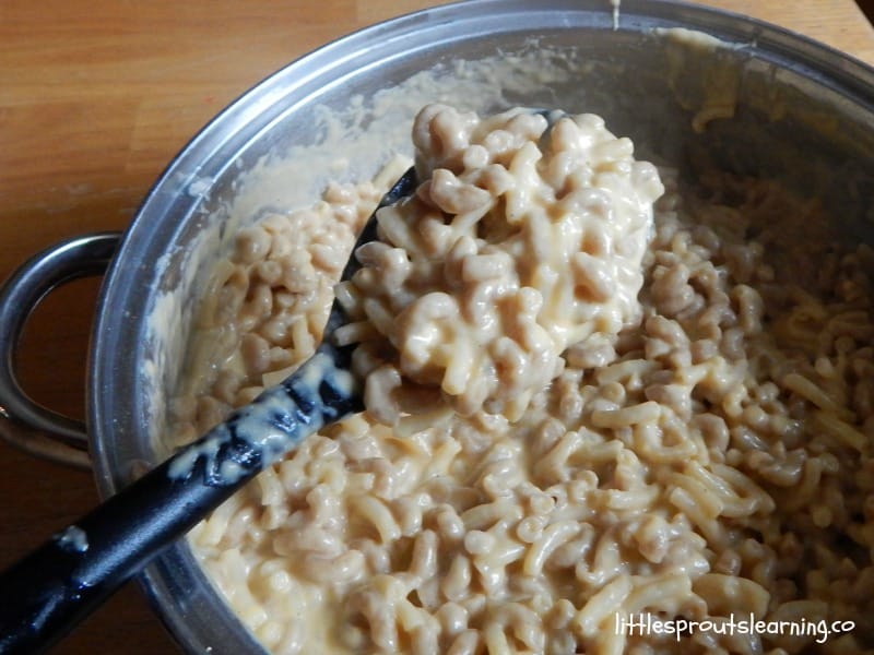 meatless mac and cheese in a pan on the stove with a big spoon full coming up