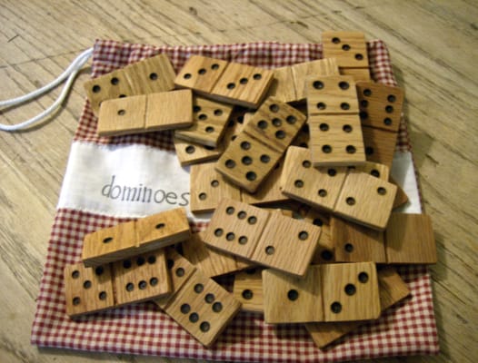 homemade wooden dominoes in a pile on top the bag