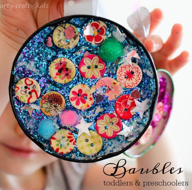 sun catcher Christmas ornament gift made by kids with glitter, buttons, pom poms and sequins.
