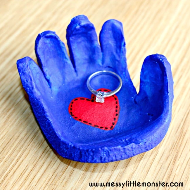 salt dough dish in the shape of a child's hand. Painted blue with a red heart in the center and a ring in the dish, great christmas gift for parents from kids