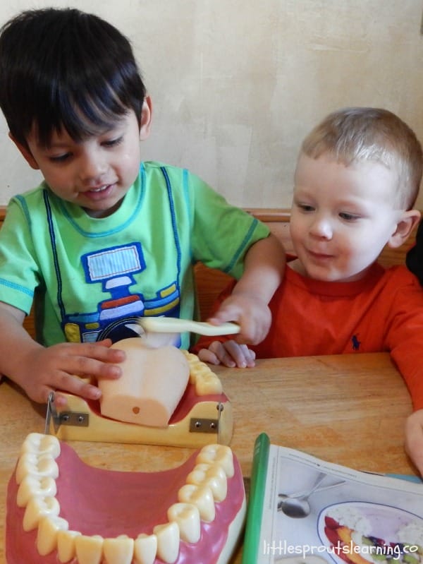 Kids brushing big teeth model with big tooth brush
