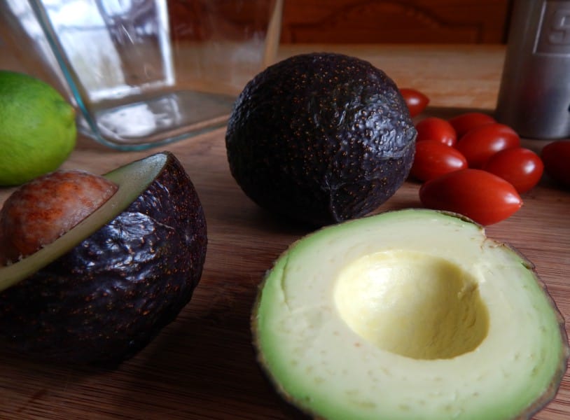 avocados, limes, and tomatoes on a cutting board