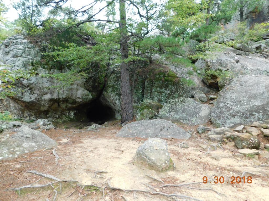 Robbers cave and rocks and trees surrounding it. 