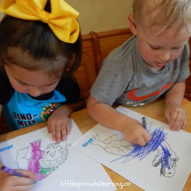 kids at the table coloring dinosaur color sheets