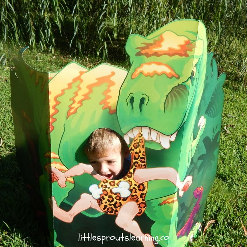 cardboard dinosaur chasing kids at dino party