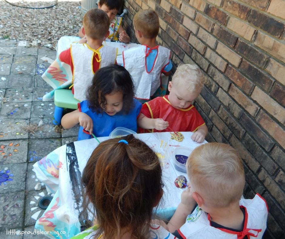 kids at tables painting garden rocks