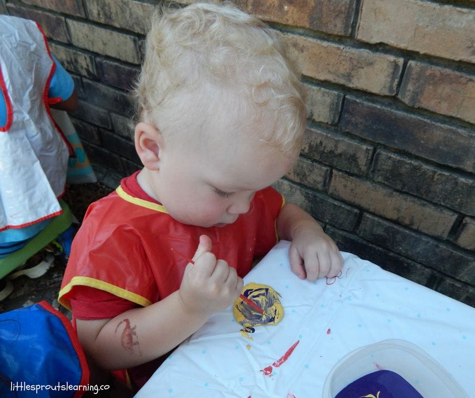 child painting garden rock