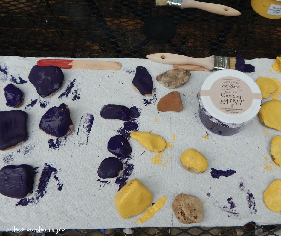 paints, paint brushes and rocks to paint for the garden