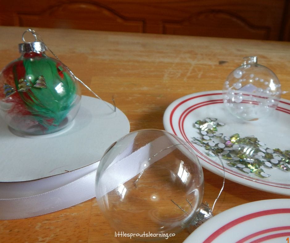 clear ornaments with feathers and pearls inside