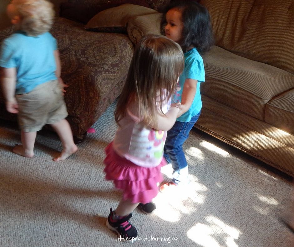 kids holding hands dancing around at dance party for kids