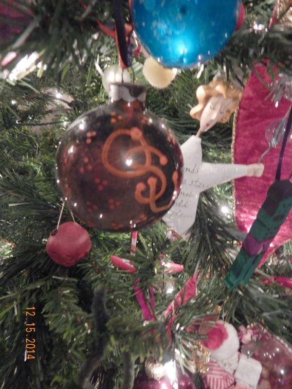 clear ornament painted black inside and decorated with osu on the outside hanging on a christmas tree
