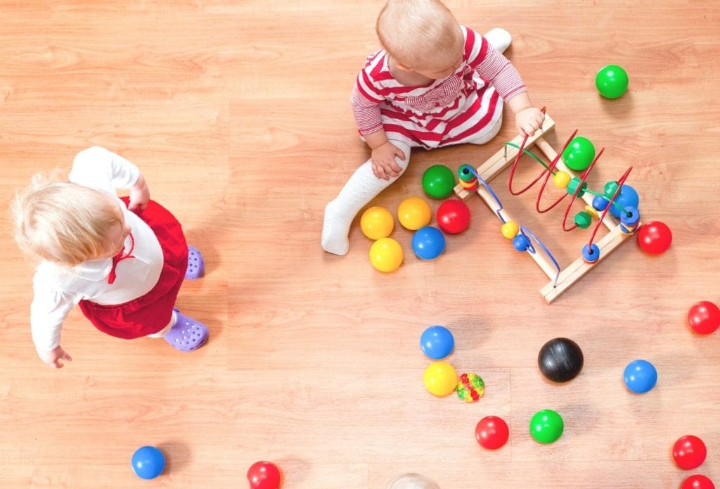 toddlers playing well together with balls and busy beads
