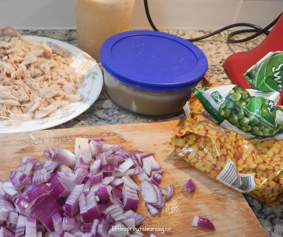 cutting board with onions, frozen vegetables and stock, frozen shredded turkey and frozen gravy for a quick and easy soup