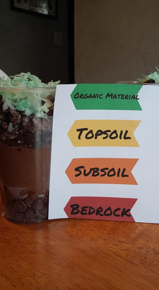 cup of snacks with different layers like the layers of soil in teh garden, organic material, topsoil, subsoil and bedrock