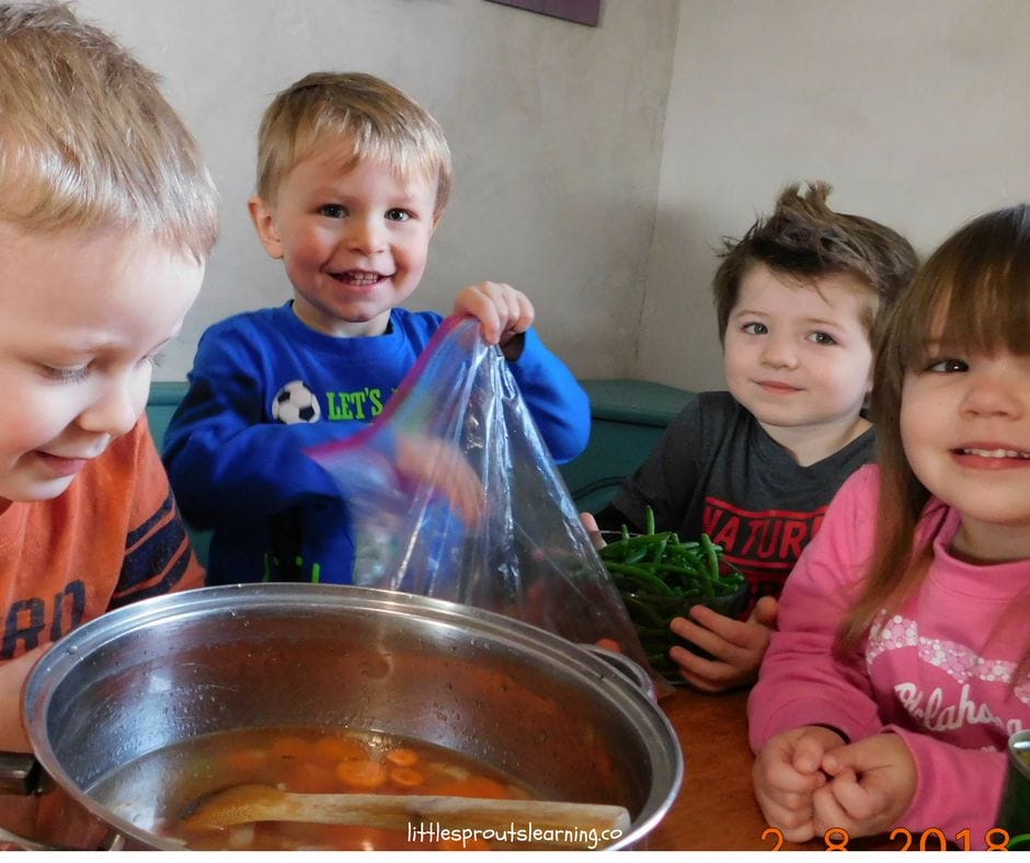 kids making friendship soup by sharing vegetables they brought from home to share.