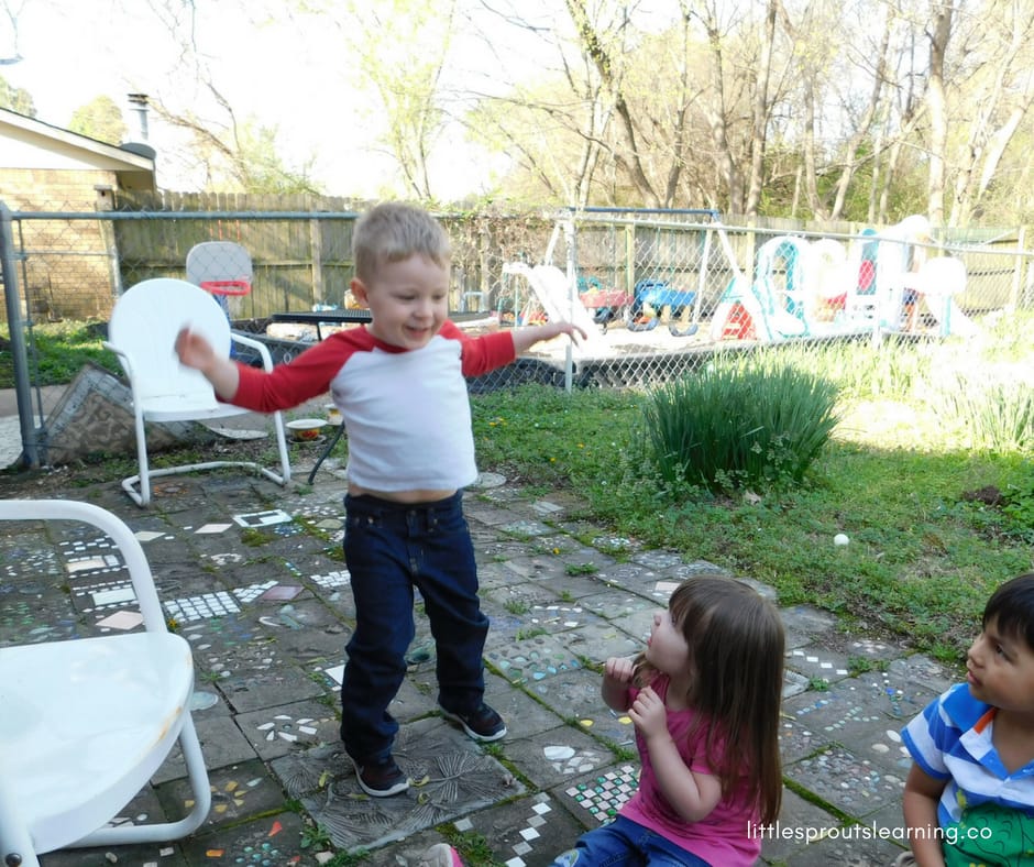 preschool kids playing animal cherades. One child is acting out an animal while the others are watching