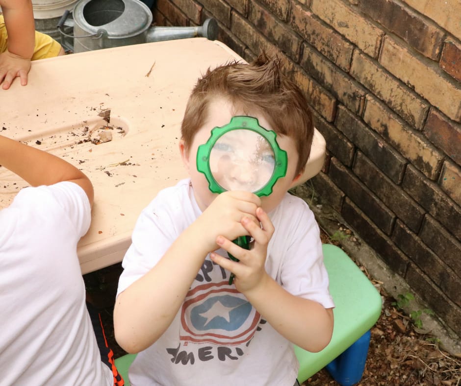 Kid looking through magnifying glass