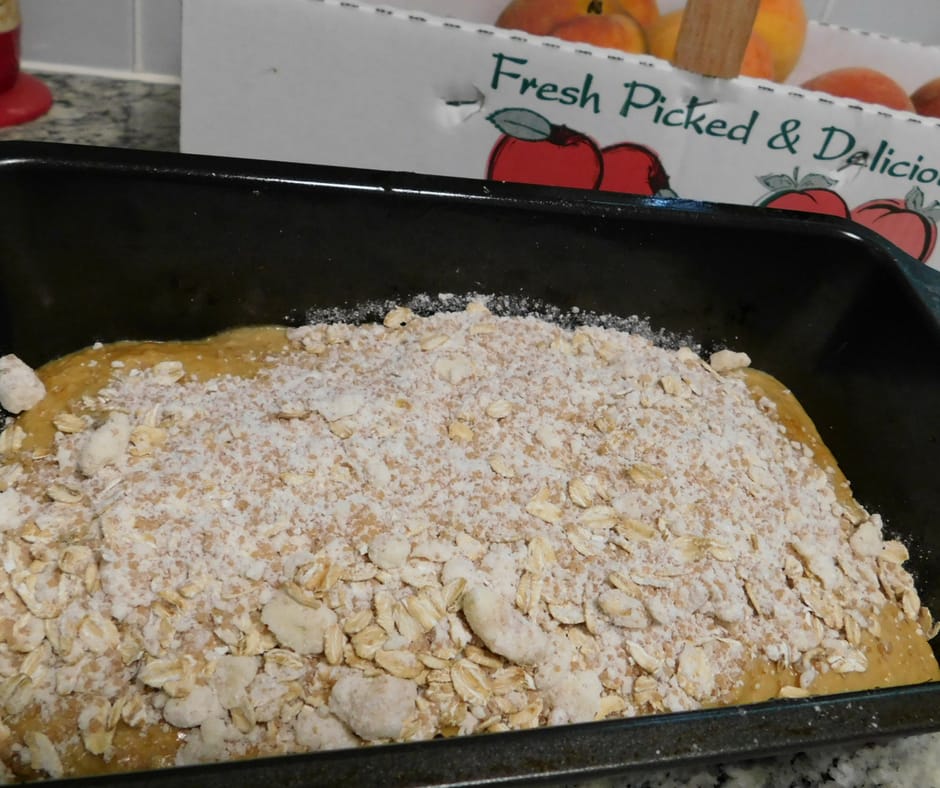 raw loaf of peach bread with cobbler topping about to go into the oven