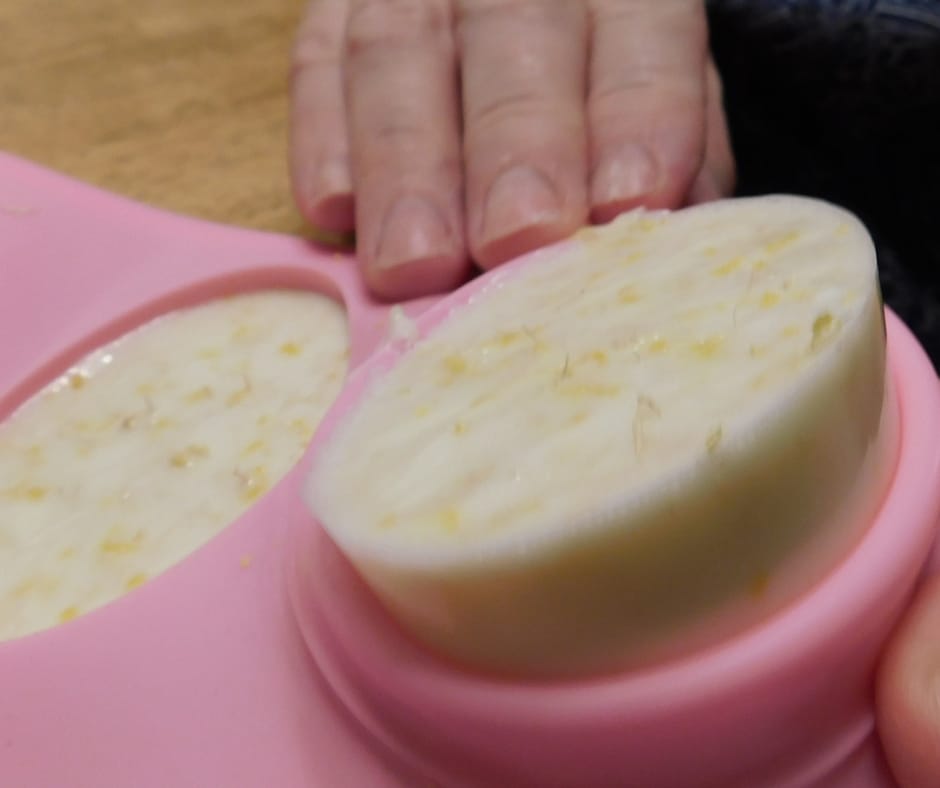Homemade lemon luffa bar soap coming out of the soap mold