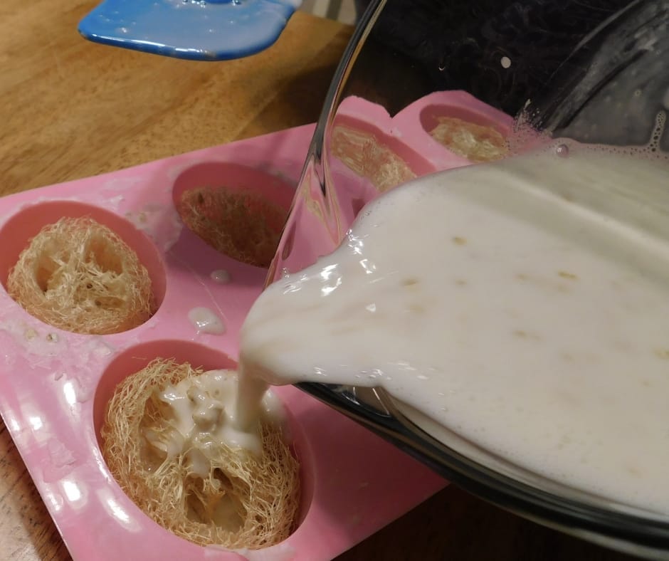 liquid oatmeal luffa soap being poured into molds over slices of loofah