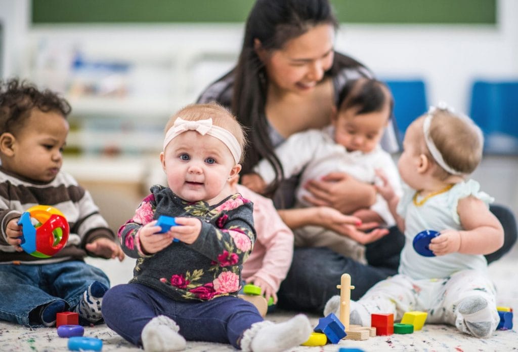 daycare provider with children loving them and caring for them. children playing happily.