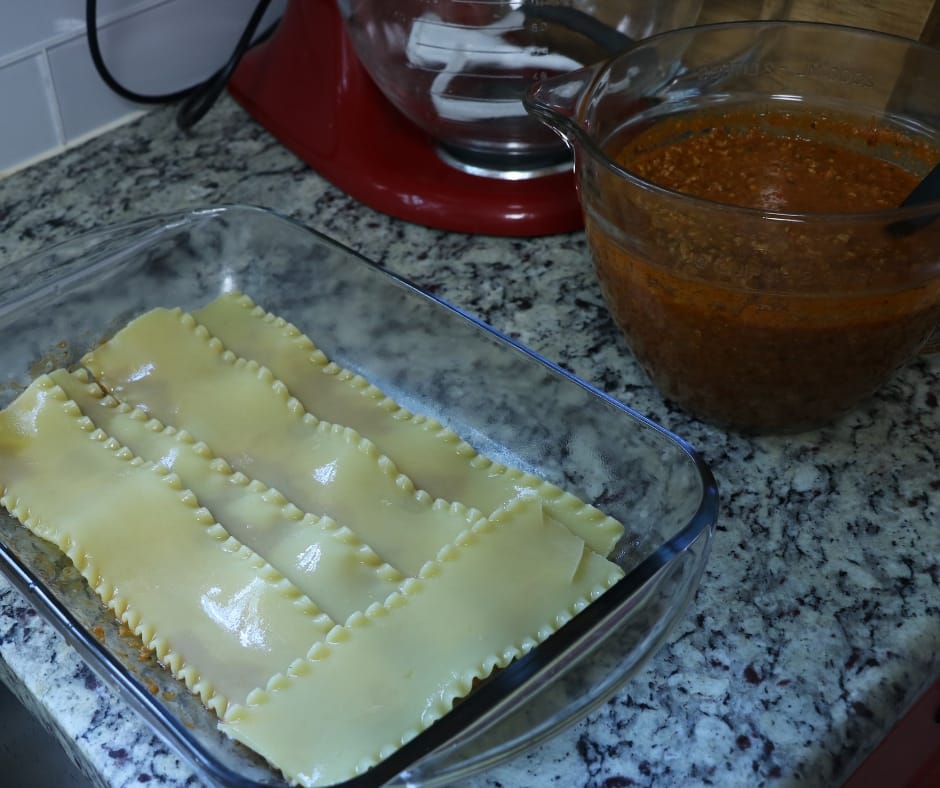 Lasagna pan with single layer of cooked lasagna noodles on bottom