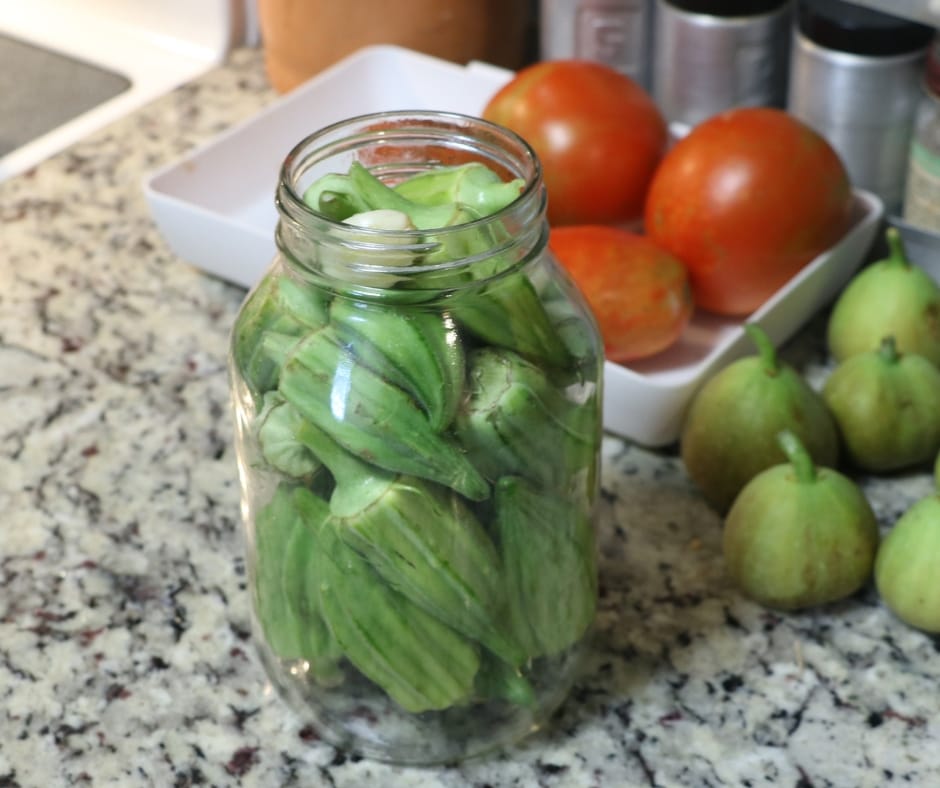 canning jar on counter top filled with okra ready to make refrigerator pickled okra